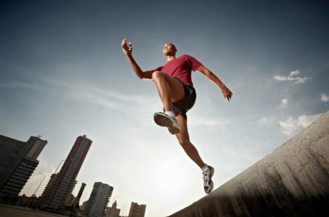 Фото спортсмена в прыжке на фоне города